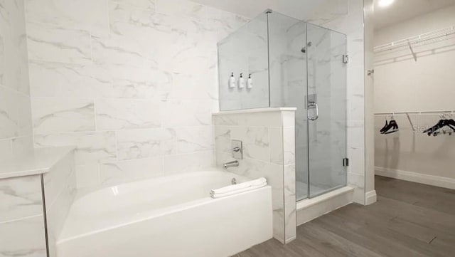 bathroom featuring wood-type flooring and separate shower and tub