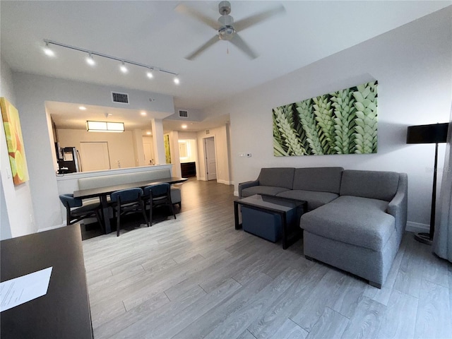 living room with light hardwood / wood-style flooring and ceiling fan