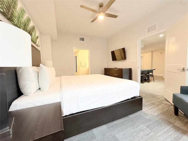 bedroom with light colored carpet, ceiling fan, and ensuite bathroom