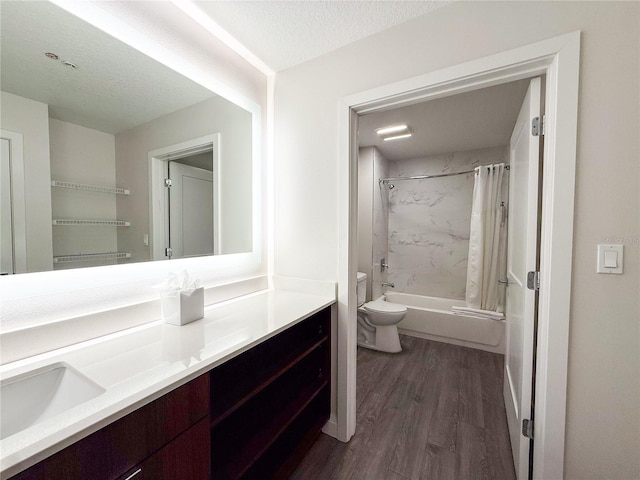 full bathroom with wood-type flooring, vanity, toilet, shower / bathtub combination with curtain, and a textured ceiling