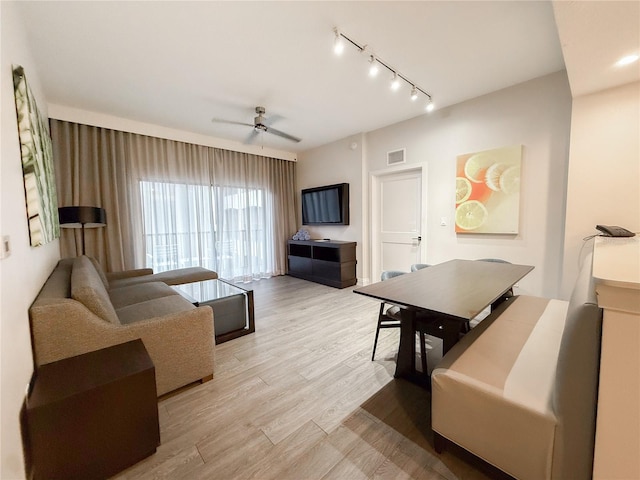 living room featuring ceiling fan, track lighting, and light hardwood / wood-style flooring