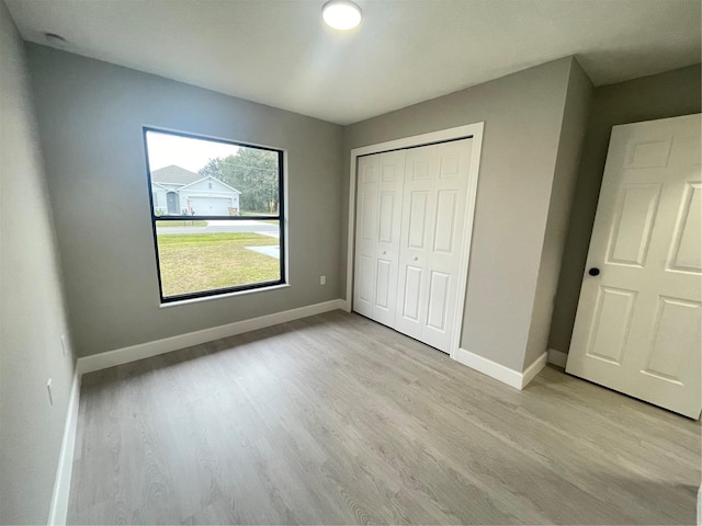 unfurnished bedroom featuring light hardwood / wood-style floors and a closet