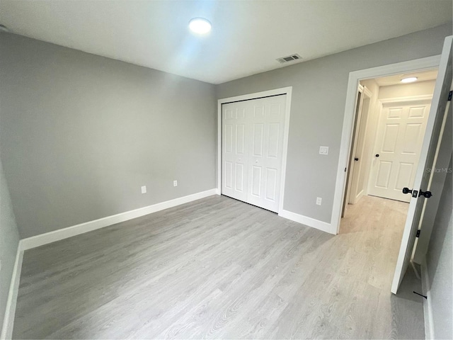 unfurnished bedroom with light hardwood / wood-style floors and a closet