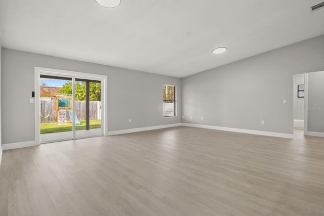 spare room with a wealth of natural light and light hardwood / wood-style floors