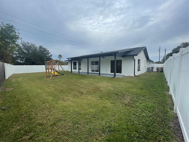 202 Cobalt Dr, Kissimmee, FL 34758 - back of property with a playground, a patio, and a fenced backyard