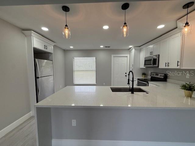 202 Cobalt Dr, Kissimmee, FL 34758 - kitchen with stainless steel appliances, a peninsula, recessed lighting, white cabinetry, and light stone counters