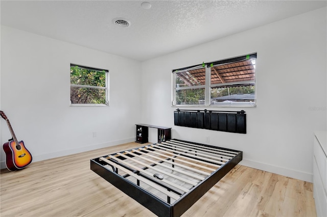 bedroom featuring hardwood / wood-style flooring and a textured ceiling