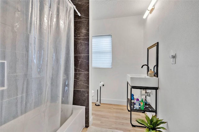 bathroom featuring sink, wood-type flooring, and shower / bathtub combination with curtain