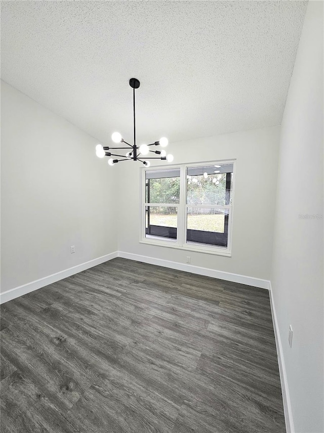 spare room with an inviting chandelier and a textured ceiling