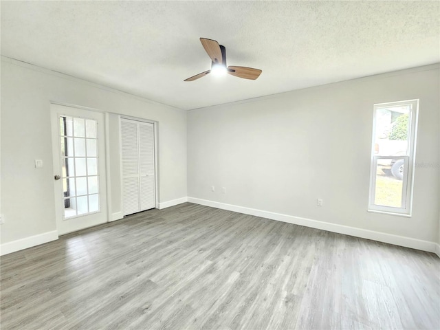 spare room featuring ceiling fan, light hardwood / wood-style flooring, and a textured ceiling