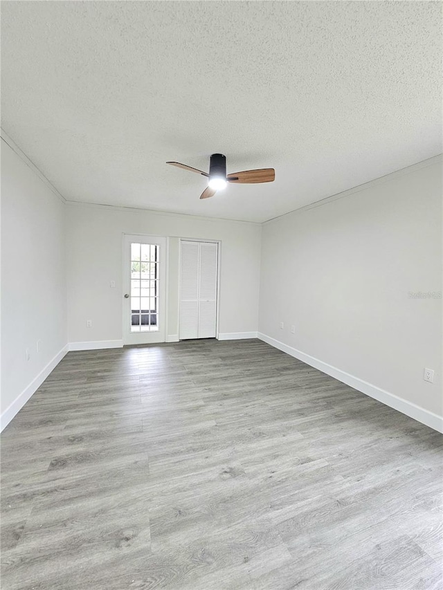 unfurnished room with light wood-type flooring, ceiling fan, and a textured ceiling