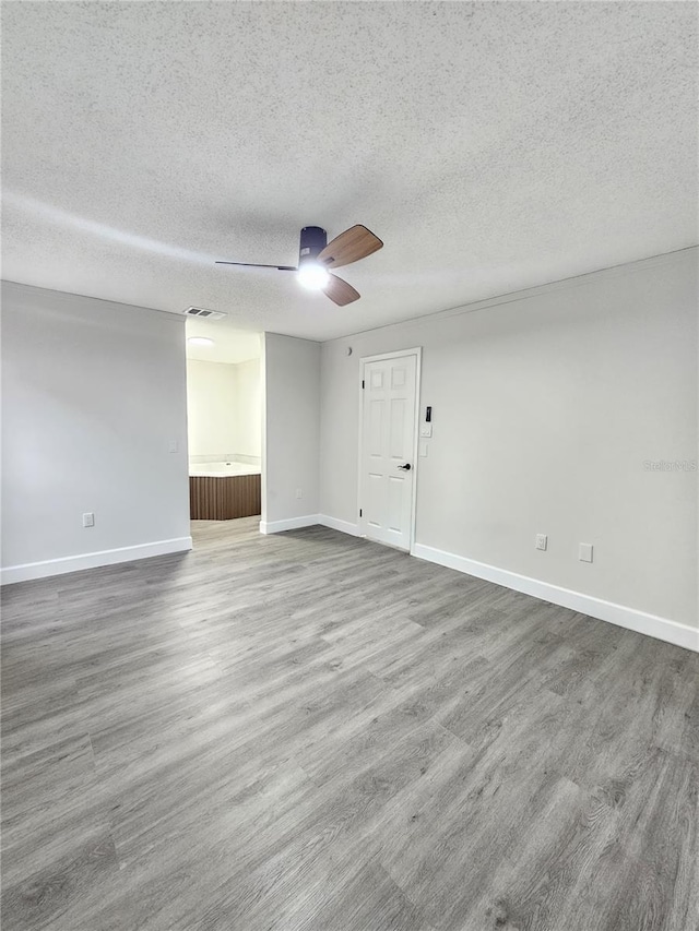 unfurnished room with wood-type flooring, a textured ceiling, and ceiling fan