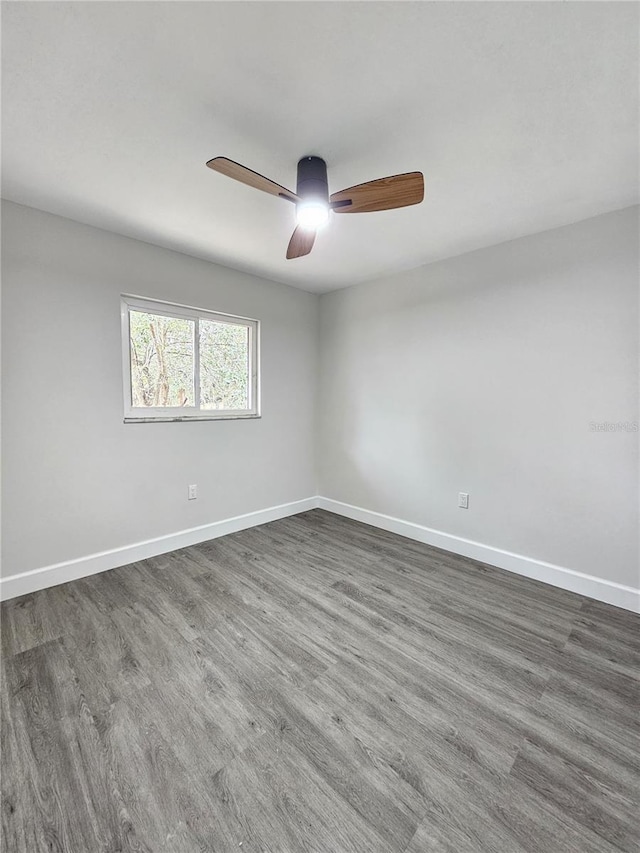 unfurnished room with ceiling fan and dark wood-type flooring