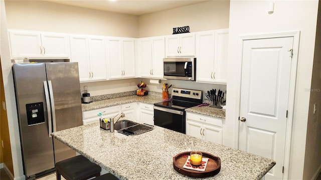 kitchen featuring light stone counters, white cabinets, and appliances with stainless steel finishes