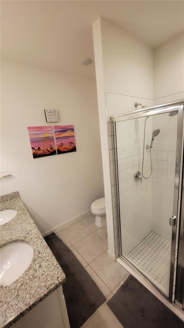 bathroom with toilet, tile patterned flooring, a shower with door, and vanity