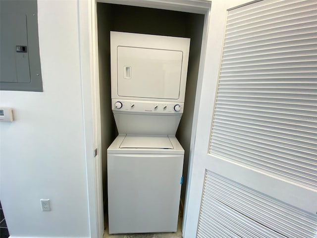 washroom with stacked washer / drying machine and electric panel