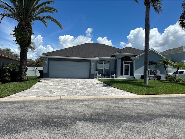 single story home featuring a front lawn and a garage