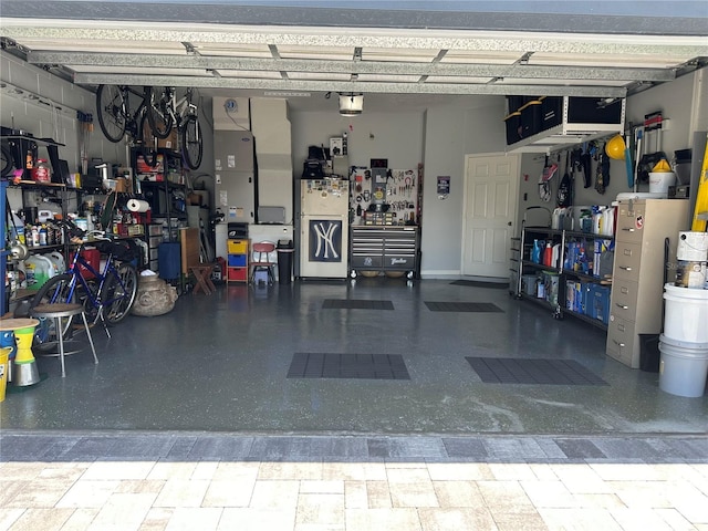 garage with a workshop area and white refrigerator with ice dispenser