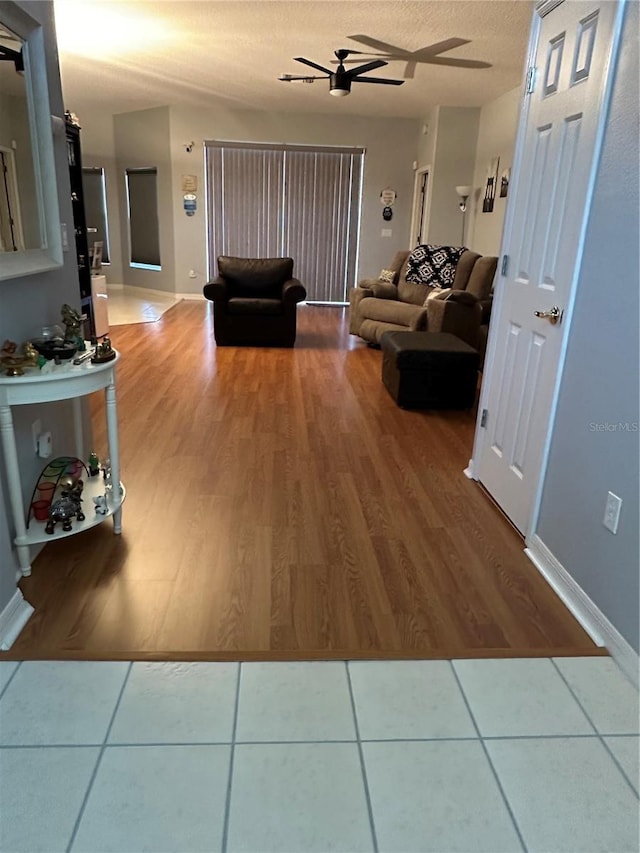 living room with a textured ceiling and ceiling fan