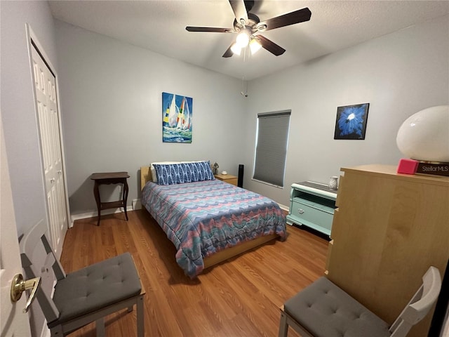 bedroom featuring wood-type flooring, ceiling fan, and a closet