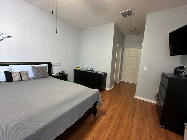 bedroom with a textured ceiling and hardwood / wood-style floors