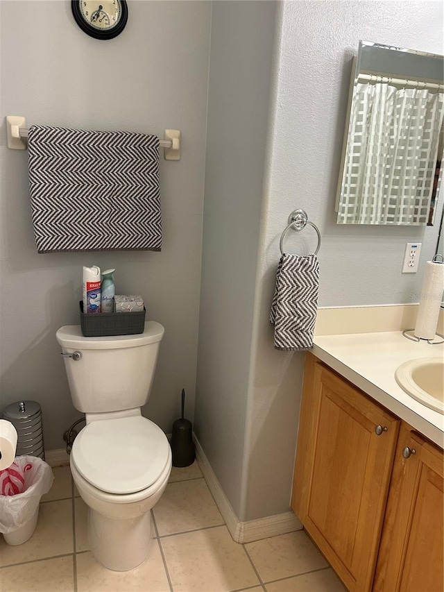 bathroom with toilet, tile patterned flooring, and vanity