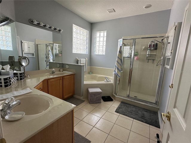 bathroom with a textured ceiling, separate shower and tub, tile patterned floors, and vanity