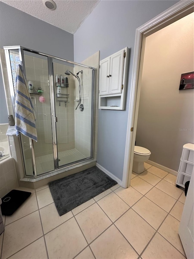 bathroom with toilet, tile patterned flooring, a textured ceiling, and separate shower and tub