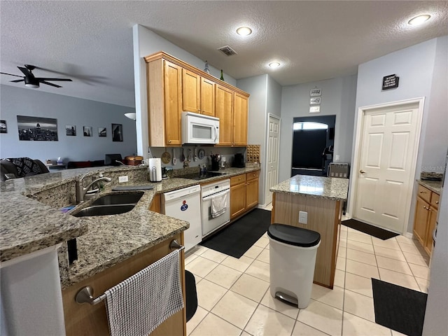 kitchen with white appliances, kitchen peninsula, light stone countertops, light tile patterned flooring, and sink