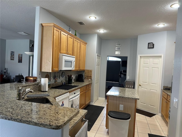 kitchen featuring white appliances, kitchen peninsula, light tile patterned flooring, and sink