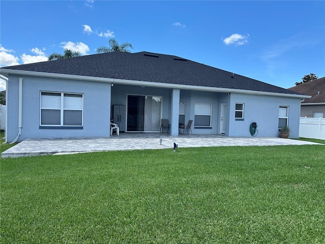 rear view of property featuring a lawn and a patio