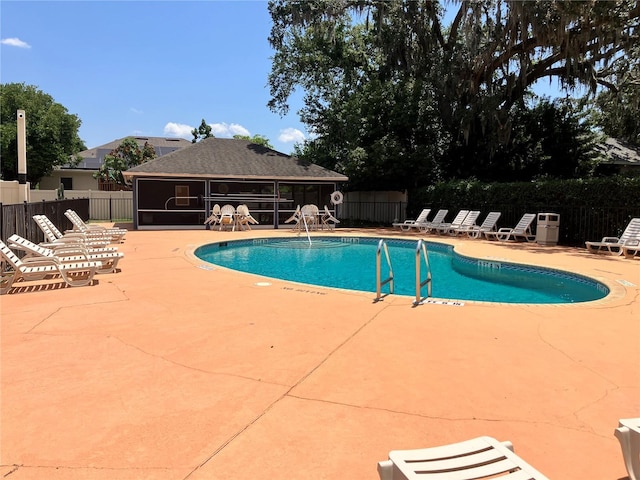 148 Joewood Trl, Davenport, FL 33837 - community pool with a patio area and a sunroom