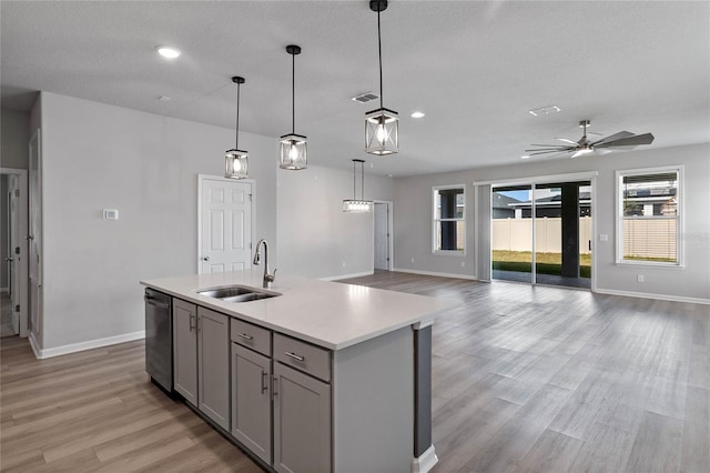 kitchen with dishwasher, pendant lighting, a center island with sink, gray cabinetry, and sink