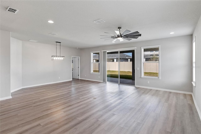 spare room with light hardwood / wood-style floors, ceiling fan, and a textured ceiling