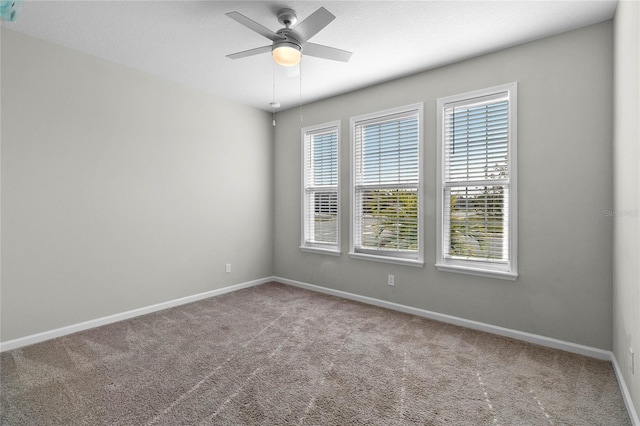 carpeted spare room with ceiling fan