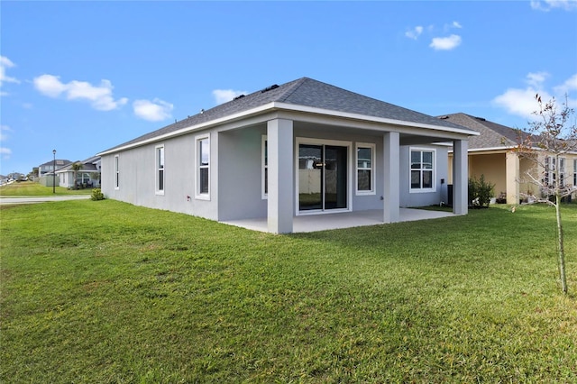 back of house featuring a lawn and a patio area