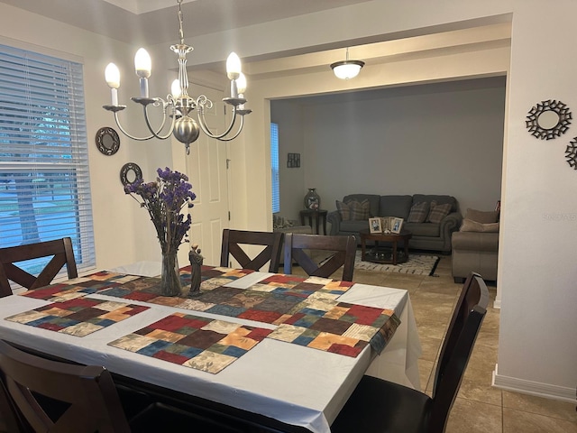 tiled dining room with an inviting chandelier