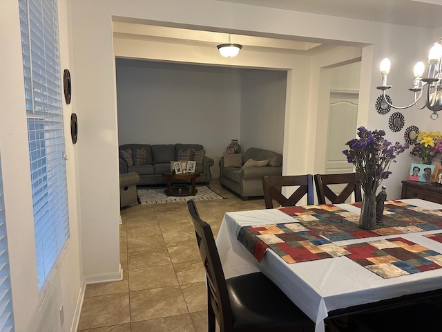 dining area featuring light tile patterned floors and a chandelier