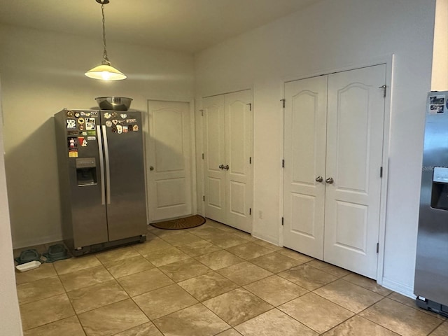 kitchen featuring pendant lighting, stainless steel fridge with ice dispenser, and light tile patterned flooring