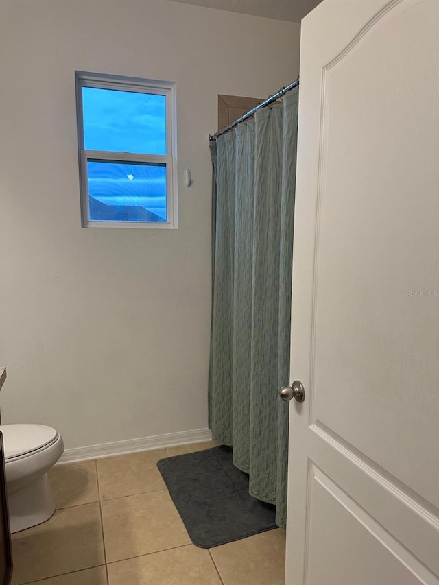 bathroom with toilet, tile patterned floors, and a shower with shower curtain