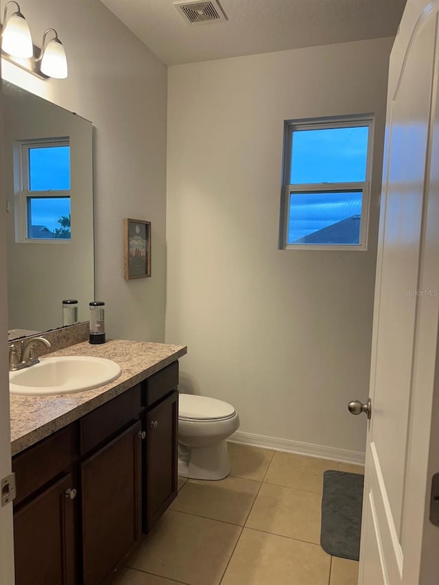 bathroom with toilet, tile patterned flooring, and vanity