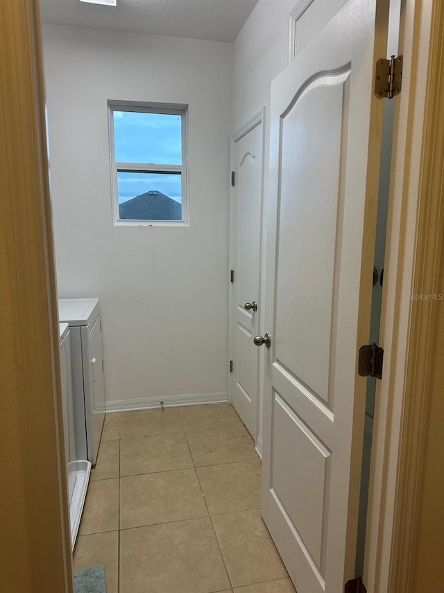 washroom featuring washer and clothes dryer and light tile patterned floors