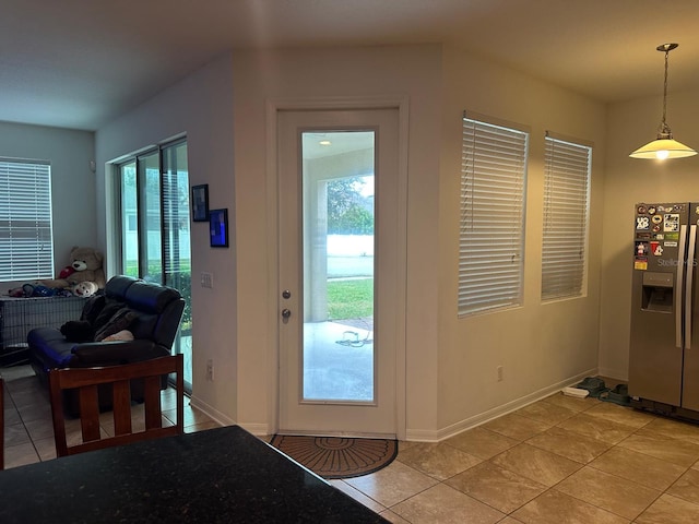 doorway to outside with light tile patterned flooring