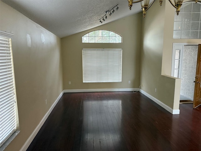 unfurnished dining area with a textured ceiling, an inviting chandelier, vaulted ceiling, and dark hardwood / wood-style floors