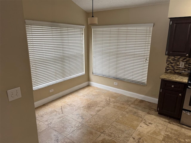 unfurnished dining area with lofted ceiling and a textured ceiling