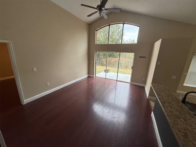 unfurnished living room featuring sink, a textured ceiling, vaulted ceiling, ceiling fan, and dark hardwood / wood-style flooring