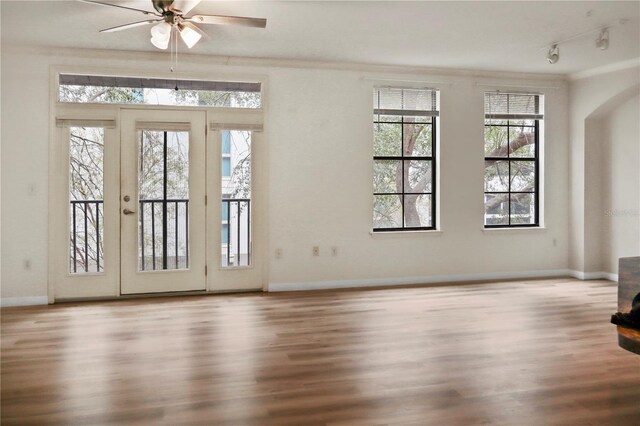 interior space with ceiling fan, ornamental molding, french doors, and light wood-type flooring