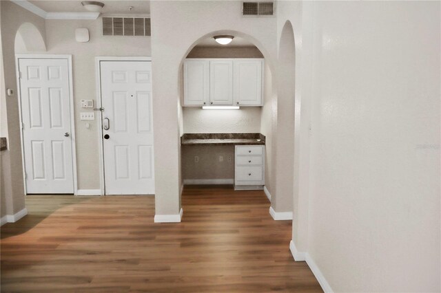 foyer entrance with dark hardwood / wood-style flooring and ornamental molding