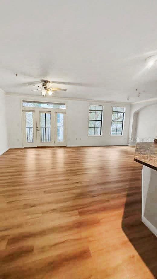 unfurnished living room featuring ceiling fan and hardwood / wood-style flooring