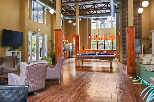 game room featuring french doors, a towering ceiling, wood-type flooring, and billiards